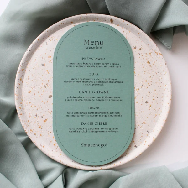 zielone menu weselne Eukaliptus w kolorze matcha z minimalistycznym składem tekstu, ułożone na talerzu