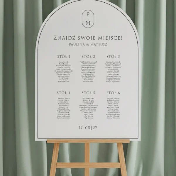 łukowa tablica z rozpisanymi stołami i imionami gości, z subtelnym monogramem oraz datą ślubu