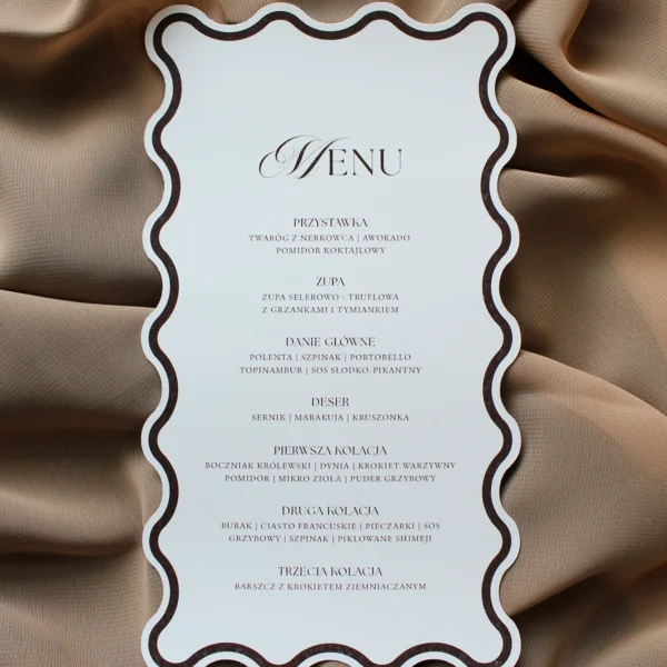 Menu weselne z kolekcji Modern Wave przewiązane brązową wstążką.