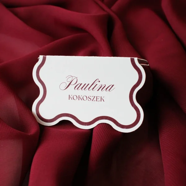 Winietka w odcieniu burgundu w pozycji stojącej, z eleganckim falowanym konturem.