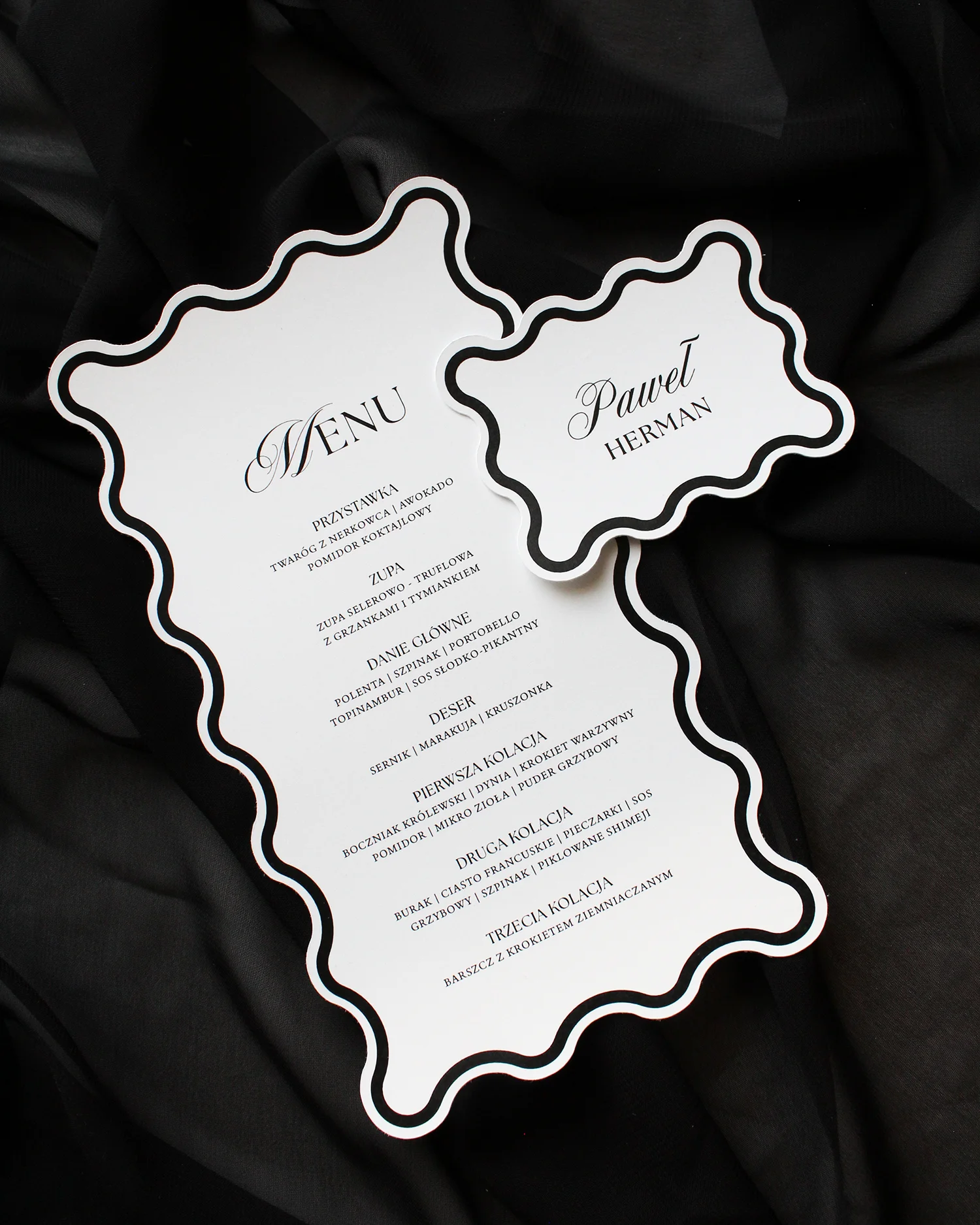 Czarne menu Modern Wave z falowaną ramką i winietką ułożoną obok, na czarnym tle.