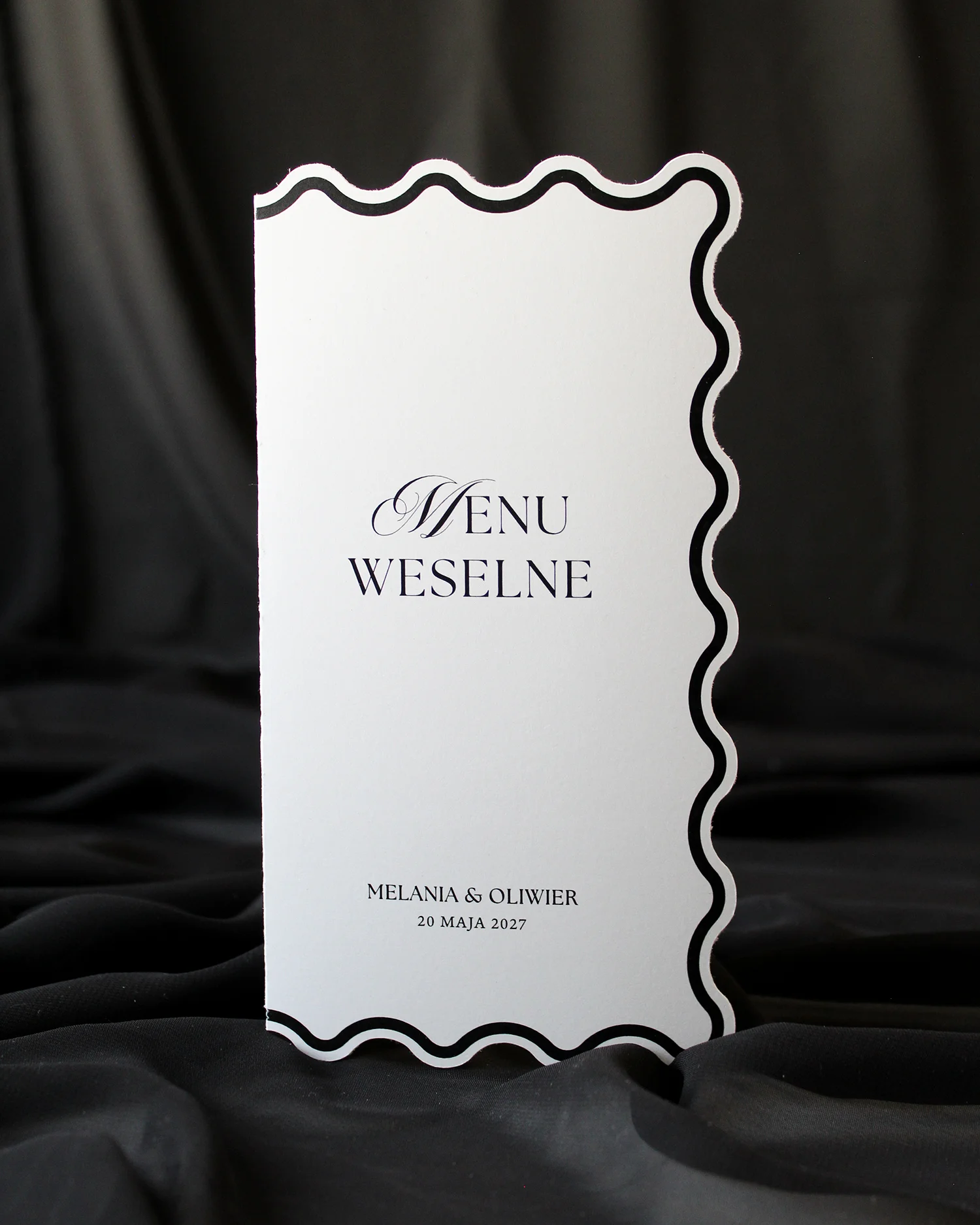 Czarne menu Modern Wave z falowaną ramką i winietką ułożoną obok, na czarnym tle.
