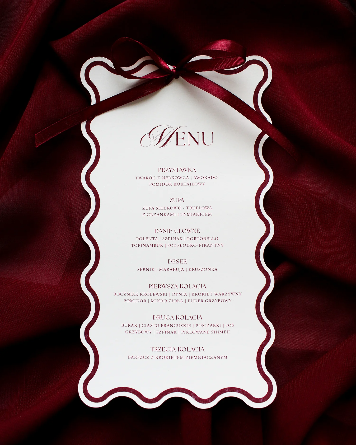 Menu weselne z dekoracyjną bordową wstążką, falowanymi krawędziami i eleganckim fontem.
