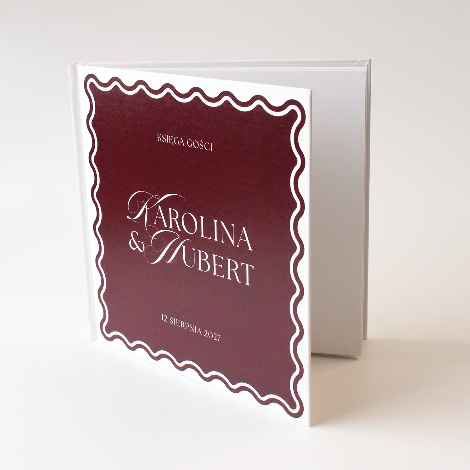 księga gości Wave Classic w kolorze burgundowym z charakterystyczną falowaną linią okładki