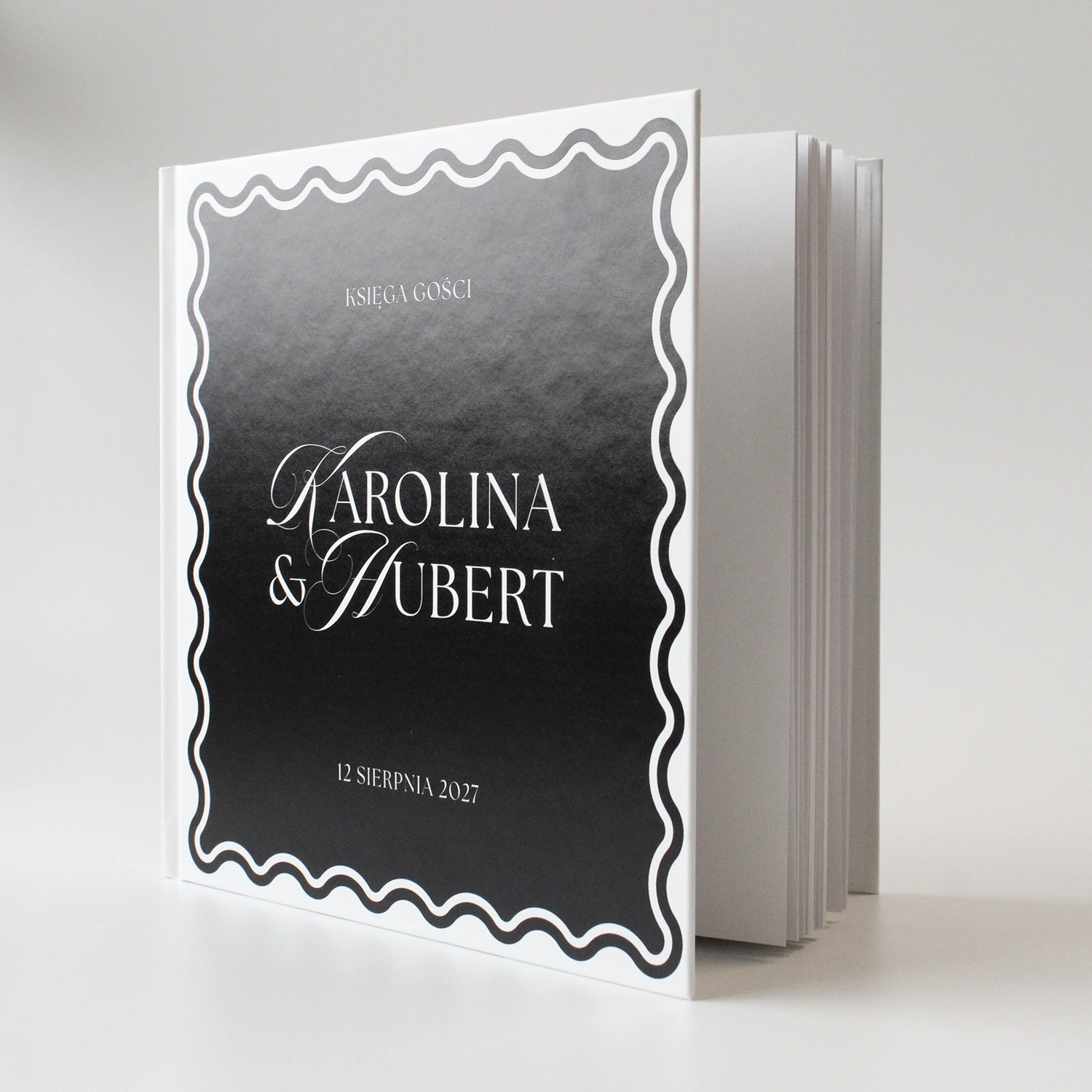 księga gości Wave Classic w kolorze czarnym z falowaną ramką i elegancką typografią