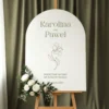 Tablica powitalna Lilia w kształcie łuku z motywem kwiatu i zieloną typografią.